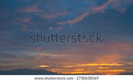 Dramatic deep purple twilight sky with a narrow golden horizon streak framed by dark tree silhouettes.