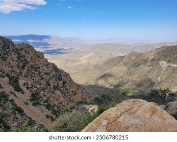 Dramatic desert view with rocky cliffs clouds and blue sky.  Beautiful vista.