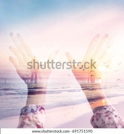 Dramatic double exposure effects on silhouette hands combined with photograph of lonely people on the ocean bridge during the sunset. Conceptual, abstract. Loneliness, freedom, dreaming, love, destiny