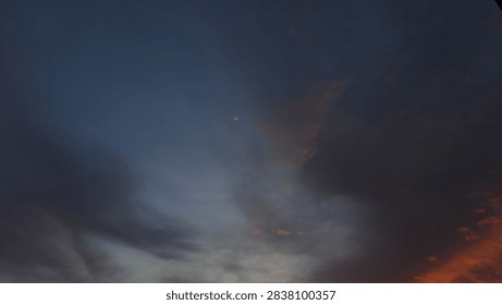 Dramatic dusk sky with dark cloudscape and vibrant orange sunset glow