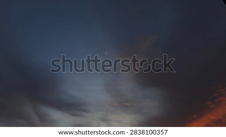 Dramatic dusk sky with dark cloudscape and vibrant orange sunset glow