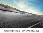 A dramatic, empty racing track under a clear sky, with spectator seats lining the sides. The stillness contrasts with the vibrant anticipation in the air, as if waiting for the action to begin.