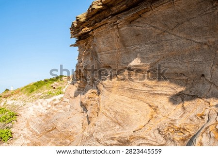 Dramatic eroded rock formations and layered geological strata on Dongshan Island, Zhangzhou. Coastal geomorphology showing natural weathering patterns and distinctive stone formations against clear bl