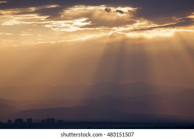 Dramatic Evening Cloudscape over Mountain Range with City Buildings