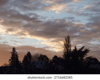 Dramatic evening sky with clouds over suburban silhouette