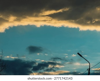 Dramatic evening sky with clouds and streetlight silhouette