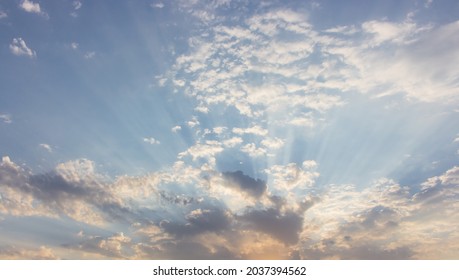 Dramatic evening sky with rays of light. Aerial view of blue sky with clouds. Heaven concept. Sunshine in the sky. Peaceful backgound. Sunset scenic sky. Sun rays through the clouds.