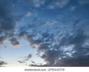 Dramatic evening sky with scattered clouds in a calm blue atmosphere, capturing the beauty of nature during twilight.