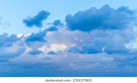 Dramatic evening sky with soft clouds illuminated by cool sunset tones, creating a calm and atmospheric twilight scene