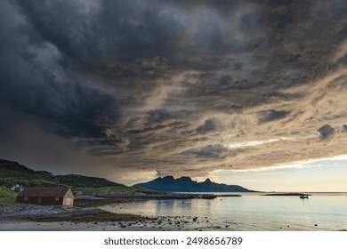 Dramatic evening storm clouds at stunning evening over the beach at Mjelle in Northern Norway pouring rain