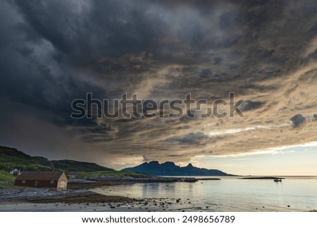 Dramatic evening storm clouds at stunning evening over the beach at Mjelle in Northern Norway pouring rain