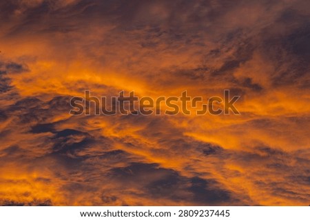 Dramatic Fiery Orange Sunset Sky with Swirling Textured Wave Cloud Formations Golden Hour Landscape