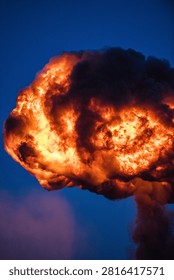 Dramatic fireball explosion creating intense flames, smoke and glowing light during a pyrotechnic demonstration or special effects performance.