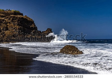 Dramatic footage of powerful Atlantic Ocean waves crashing against the rocky coastline of Tenerife, Canary Islands. Rough sea conditions, dangerous surf, and strong currents make swimming unsafe near the black volcanic sand beach. Natural forces, coastal hazards, extreme weather, and the rugged beauty of the volcanic shoreline create a striking travel and nature scen