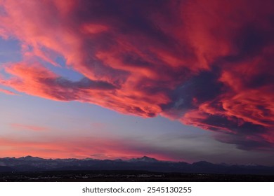 dramatic front of clouds moving in  across long's peak and the front range of the colorado rocky mountains  at sunset in winter, as seen from broomfield, colorado 