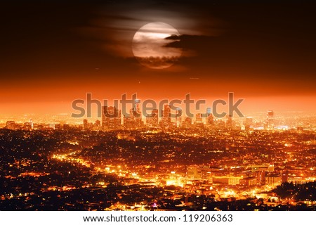 Dramatic full moon over Los Angeles skyline at night.