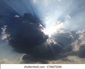 Dramatic god lights passing through clouds and shining on shining on sky.