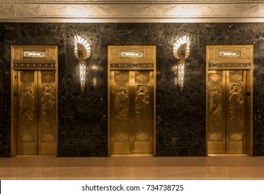 Dramatic golden elevators in fancy urban skyscraper building with relief sculptures and marble wall with lights and sconces  - Powered by Shutterstock