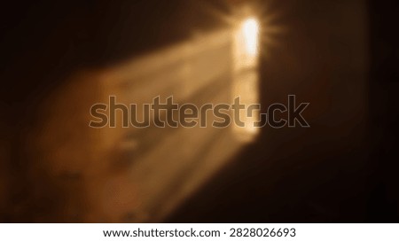 Dramatic golden light rays pierce through a dark, mysterious opening, creating a sense of hope and revelation.