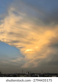 Dramatic golden sunset clouds over the city skyline horizon
