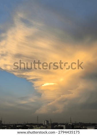 Dramatic golden sunset clouds over the city skyline horizon