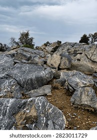 Dramatic granite rock formations creating a rugged mountain landscape beneath a soft cloudy sky.