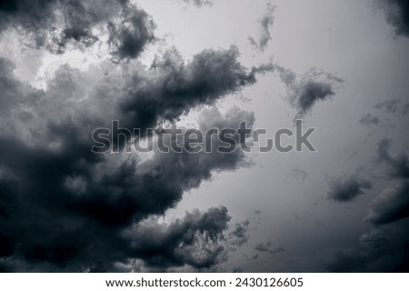 Dramatic gray-white cloudy sky with storm clouds and passing wispy clouds of a heavy thunderstorm