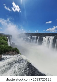 A dramatic, high-angle shot capturing the immense power of a major waterfall where the massive volume of water plunges over the edge.