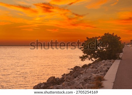 The dramatic horizon and architectural silhouette create a serene yet dynamic scene in monochrome, Soft twilight tones highlight the waterfront skyline, enhancing the photo’s overall visual impact