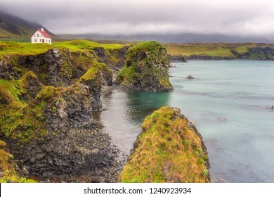 Dramatic icelandic landscape, lonely house on the volcanic cliffs seacoast, Arnarstapi, Snaefellsnes peninsula, Iceland - Powered by Shutterstock