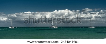 Dramatic image of the Caribbean coast in Las Terrenas with sailboats anchored in the stormy bay with cloudy skies.