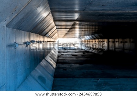 Dramatic Image inside a concrete box culvert under a road for stormwater drainage. 