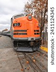 Dramatic image of a large orange train at Southern Pacific Locomotive in old town Sacramento, California in the autumn leaves.