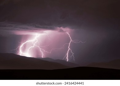 A dramatic image of a stormy sky above a mountain range, illuminated by a brilliant lightning bolt