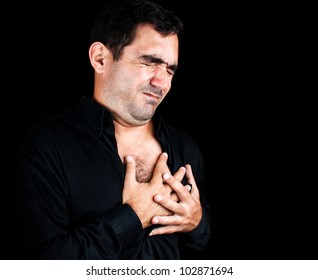 Dramatic Image Of A Young Man Having A Very Painful Heart Attack Clutching His Chest Isolated On Black