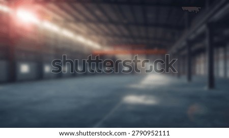 A dramatic interior shot of a large warehouse space, featuring light beams streaming through the structure. The concrete floors and industrial design create a compelling visual.