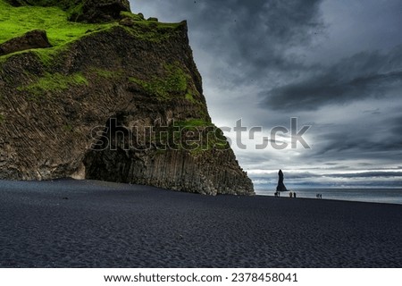 Dramatic landscape of Halsanefshellir cave with Reynisdrangar natural rock formation on Reynisfjara black sand beach in gloomy day during summer at South of Iceland