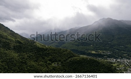 Dramatic landscape of rain falling on green mountains and valley in the french Alps, Auvergne rhone Alpes region, France