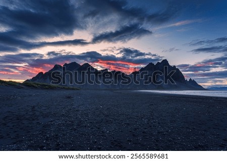 Dramatic landscape of sunset sky over volcanic Vestrahorn mountain on black sand beach in summer at Stokksnes peninsula, Iceland