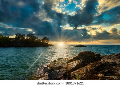 Dramatic Landscape Sunset In Sweden By The Lake Vättern. Rock In Foreground