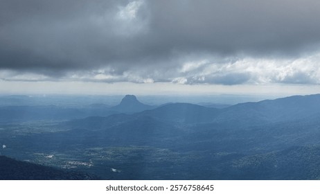 A dramatic landscape view of a mountain range under a cloudy sky, capturing the natural beauty and vastness of the terrain.
