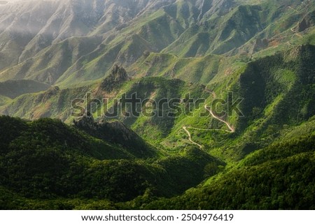 Dramatic landscape view of rugged green hills and curvy country road, Anaga, Tenerife, Spain