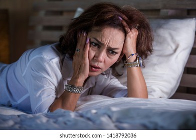 Dramatic Lifestyle Portrait Of Attractive Sad And Depressed Middle Aged Around 50s Woman Feeling Upset Alone On Bed Suffering Depression And Anxiety Crisis As Mature Lady Lost And Confused 