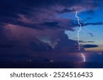 Dramatic Lightning Storm Over Pacific ocean Sea and far away island mountains before sunrise dawn.