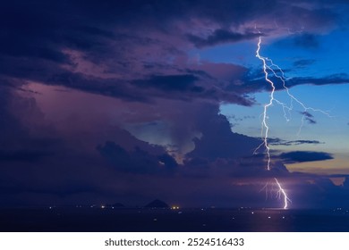 Dramatic Lightning Storm Over Pacific ocean Sea and far away island mountains before sunrise dawn.