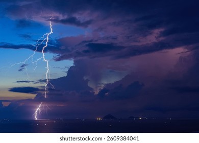 Dramatic Lightning Storm Over Pacific ocean Sea and far away island mountains before sunrise dawn early morning before sunrise electric storm