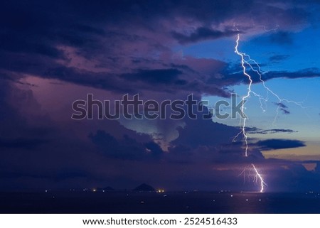 Dramatic Lightning Storm Over Pacific ocean Sea and far away island mountains before sunrise dawn.