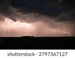 Dramatic lightning storm over rural farmhouse under dark thunderclouds and rain