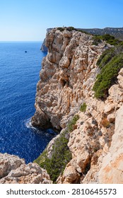 Dramatic limestone cliffs of Capo Caccia in Sardinia, Italy, overlooking the deep blue Mediterranean Sea