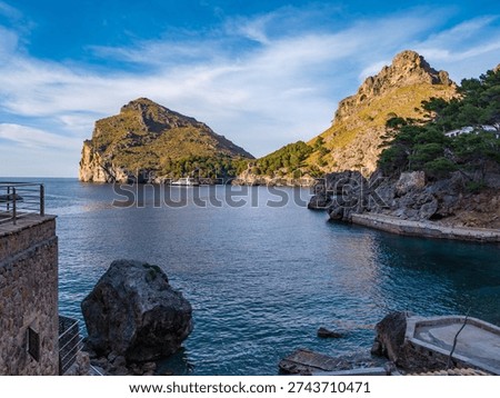 Dramatic limestone cliffs frame the secluded Torrent de Pareis cove in Mallorca, where turquoise Mediterranean waters meet rugged Balearic coastline in this pristine nature landscape.